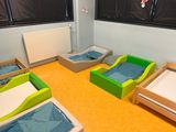 four beds in a room with a window and a radiator