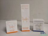 trois boîtes de produits de soin pour la peau, blancs et orange, posées sur une table