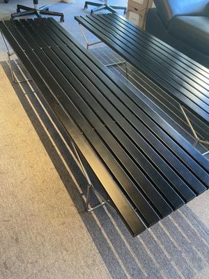 un banc noir placé dans un salon, à côté d'un canapé