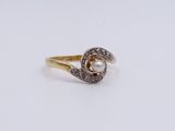 a close up of a gold ring with a pearl and diamonds