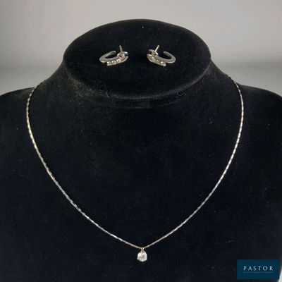 un gros plan d'un ensemble composé d'un collier et de boucles d'oreilles porté par un mannequin