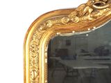 a mirror with a gold frame and a bird on it