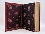 an open book with a pink flower design on it