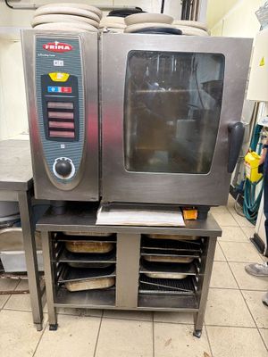 a small oven that is sitting on a stand in a kitchen