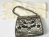 un vieux sac à main et des gants posés sur une table