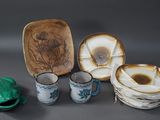 plusieurs pièces de poterie posées sur une table, à côté d'une grenouille