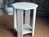 a small white table with a shelf on top of it