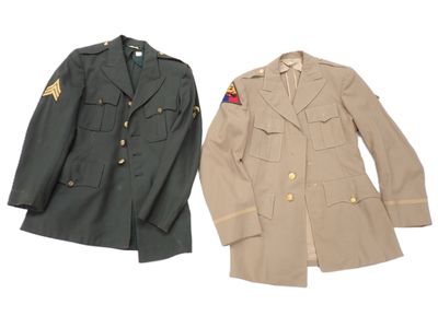 two military uniforms are displayed on a white surface