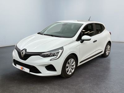 Une voiture blanche est garée dans une pièce au sol noir.