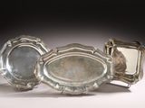 three silver trays sitting next to each other on a table