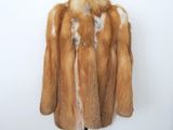 une photo d'un manteau de fourrure marron et blanc posé sur un mannequin