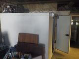 une pièce dans laquelle se trouvent un réfrigérateur et une pile de cartons