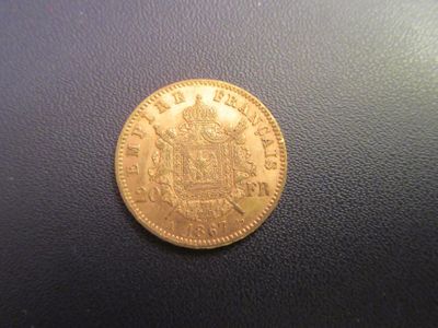 a close up of a gold coin on a black surface