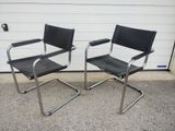 pair of chrome and black leather chairs in front of a garage door