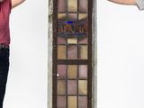 two people standing next to a tall stained glass door