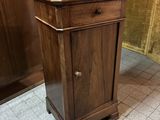 une armoire en bois surmontée d'un tiroir, dans une pièce