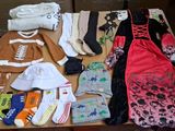 many pairs of shoes and clothes laid out on a table