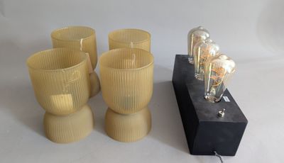 four glasses and a lamp on a table