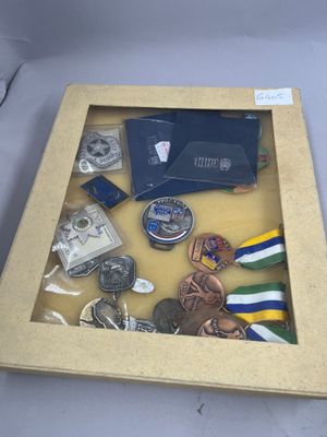 un cadre vitrine contenant des médailles et d'autres objets