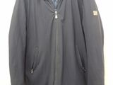 jacket with hood and zippers on a hanger on a white wall