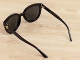sunglasses on a wooden table with a black frame and black lenses