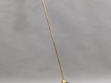 a brass floor lamp with a white shade on top of it