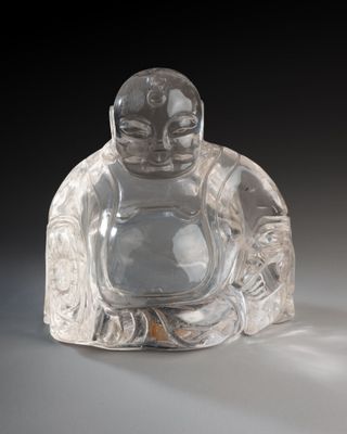 une figurine de Bouddha en verre posée sur une table