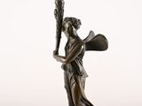 bronze statue of a woman holding a baseball bat and a ball