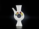 un vase blanc orné d'un motif sur un fond noir