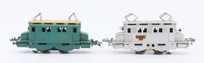 two toy trains sitting next to each other on a white surface