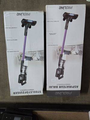 deux cartons contenant des aspirateurs posés sur une table à côté d'un ordinateur portable