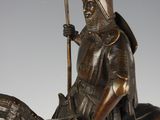 bronze statue of a man on a horse with a spear