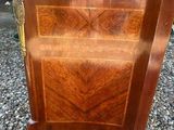 an old wooden chest of drawers sitting on top of a gravel ground