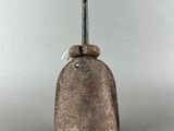 a metal bell with a bird on top of it