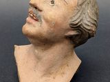 a close up of a clay bust of a man on a table