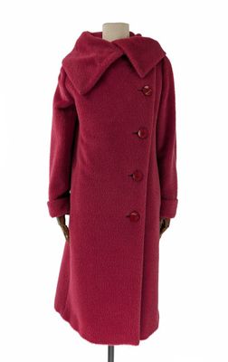 Le manteau est rouge et comporte des boutons au niveau du col.
