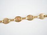 a close up of a gold chain with five circles on it