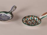two small bowls with spoons sitting next to each other