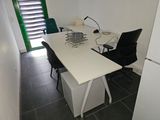 a white desk with a black chair and a white refrigerator