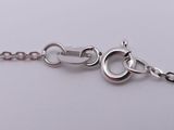a close up of a silver chain with a heart on it