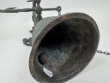 a metal bell with a chain around it on a table