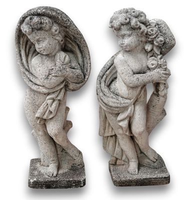 deux statues de chérubins tenant un bébé dans leurs bras