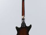 an electric guitar hanging from a string on a white background