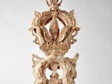 une horloge ancienne en bois surmontée d'une couronne
