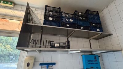 a metal shelf with baskets on it in a kitchen