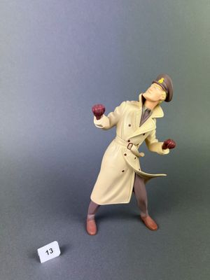 figurine représentant un homme en trench-coat et chapeau, tenant une pomme