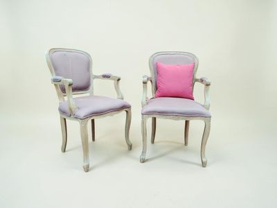 deux chaises ornées de coussins roses et violets, sur fond blanc