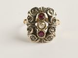 gros plan d'une bague en or avec une pierre rouge au centre