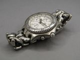 a silver watch that is sitting on a silver bracelet