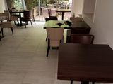 Dans un restaurant offrant une vue sur l'extérieur, les tables et les chaises sont alignées.